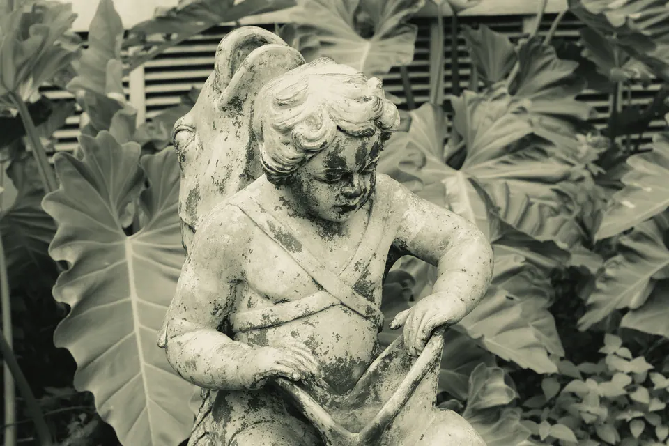 estátua de anjo entre folhagens, em tom sépia