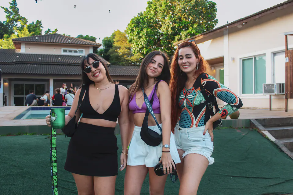 três amigas posam lado a lado na festa