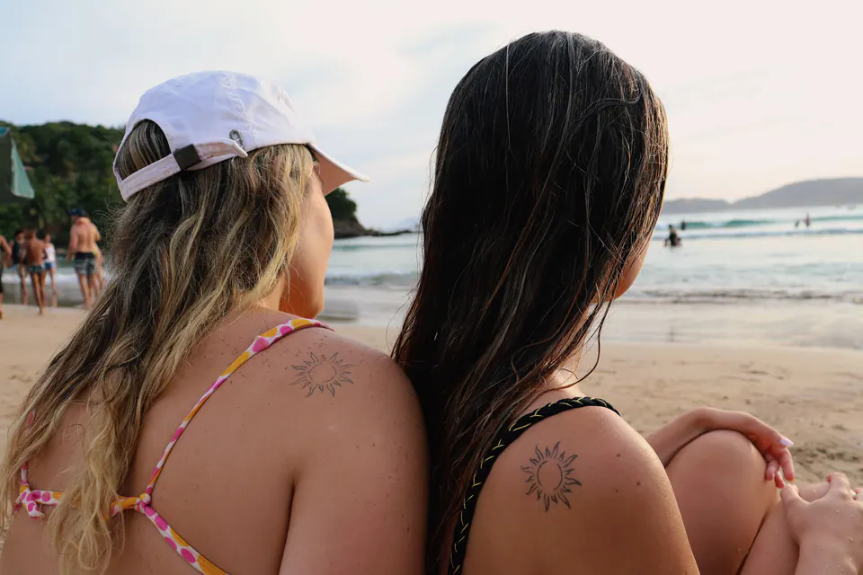 duas amigas de costas olhando o mar