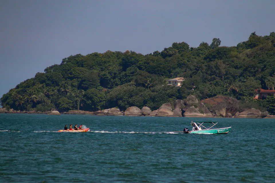 ilha verde e lanchas no mar azul