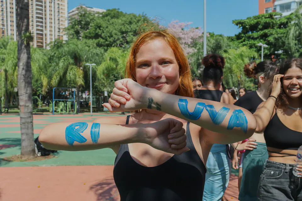 caloura estende os braços com uva ri pintado em azul