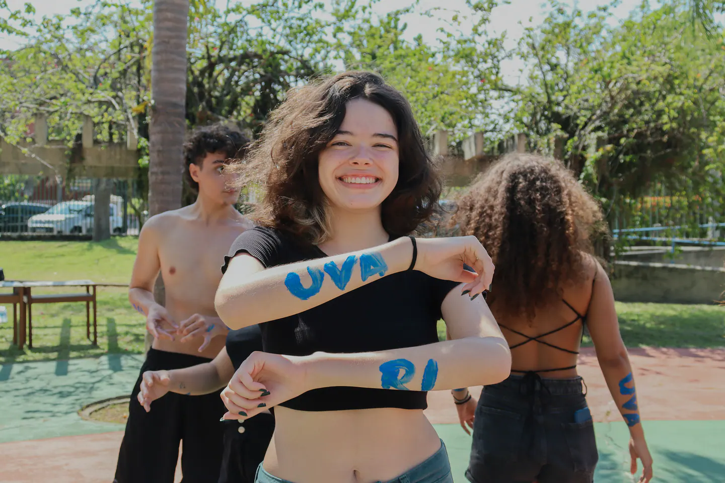 caloura sorri mostrando uva ri pintado nos braços